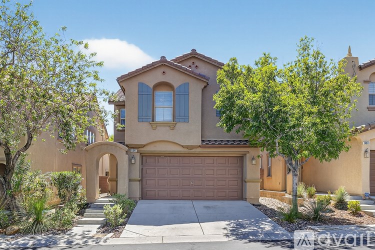 A house with a brown garage door is surrounded by green trees.