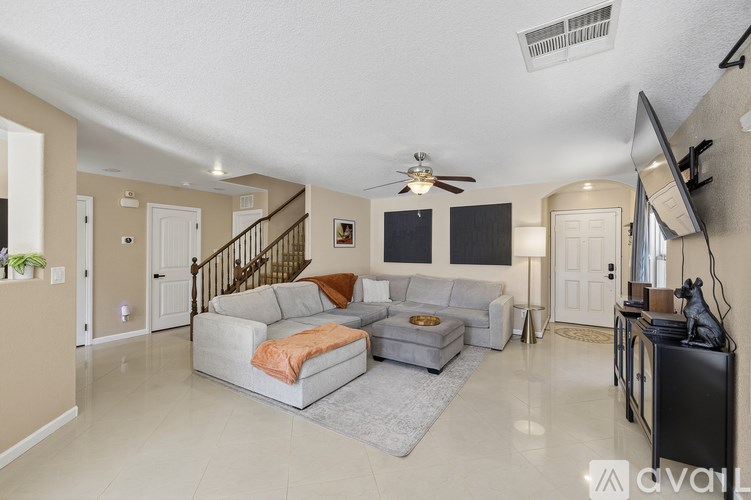 A living room with a grey couch and a television.