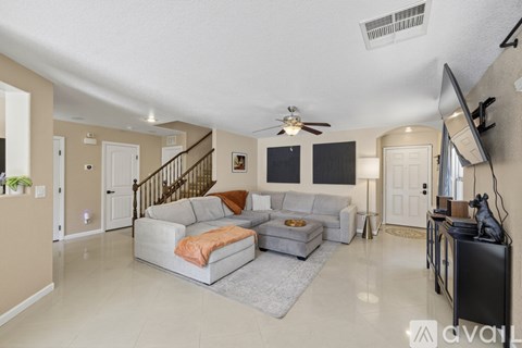 A living room with a grey couch and a television.