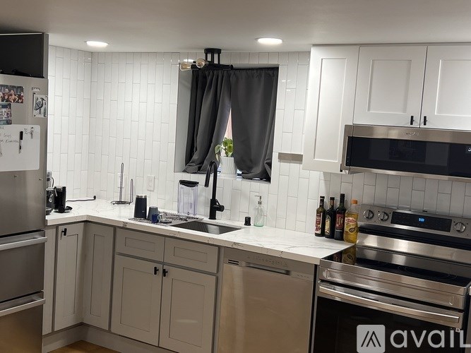A kitchen with white cabinets and a black oven.