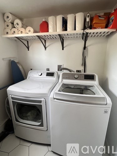 A white washing machine and dryer in a small laundry room.