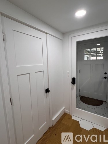 A white door with a black handle is on the left and a glass door with a black handle is on the right.