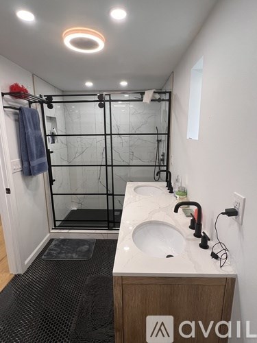 A bathroom with a glass shower door and a white countertop.