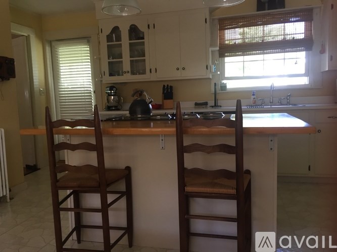 Two brown chairs are placed in front of a kitchen island.