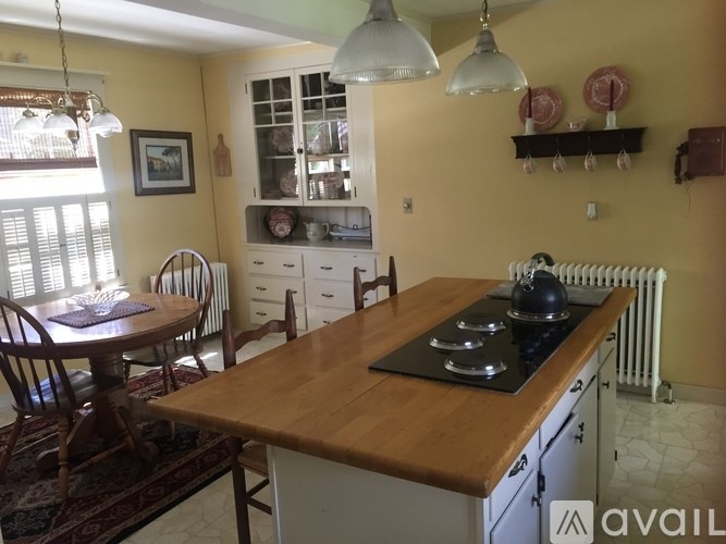A kitchen with a table and chairs.