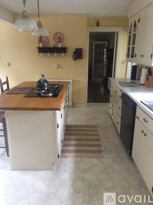 A kitchen with a wooden island and white cabinets.