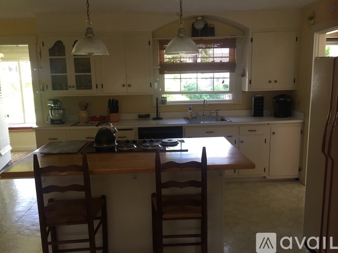 A kitchen with a table and chairs in front of a window.