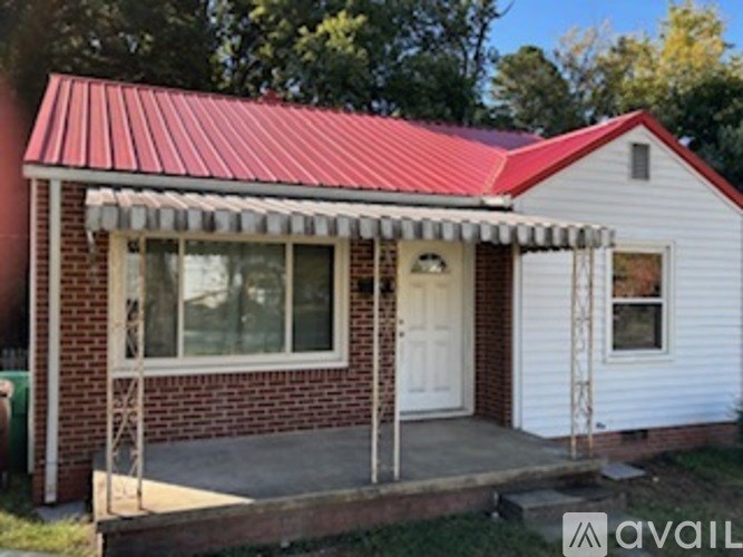 A small house with a red roof and a white door.