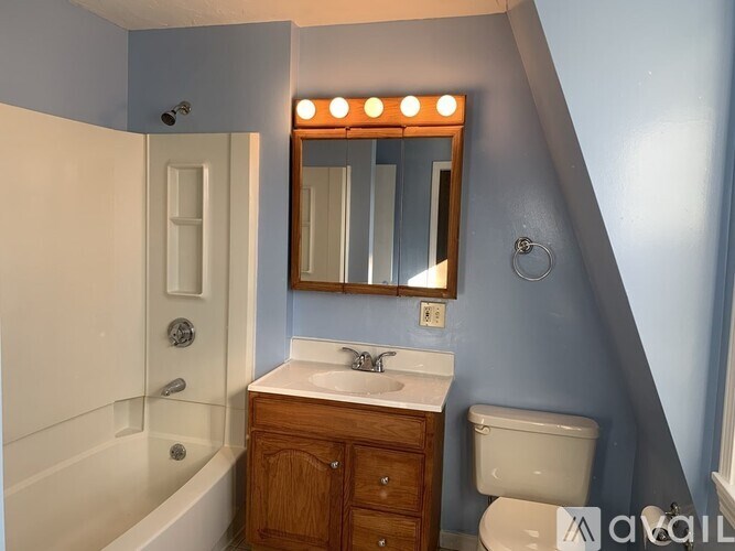 A bathroom with a white tub, sink, and toilet.