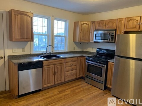 A kitchen with wooden cabinets and stainless steel appliances.