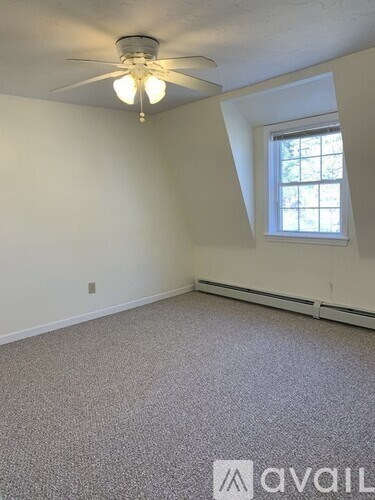 A room with a ceiling fan and a window.