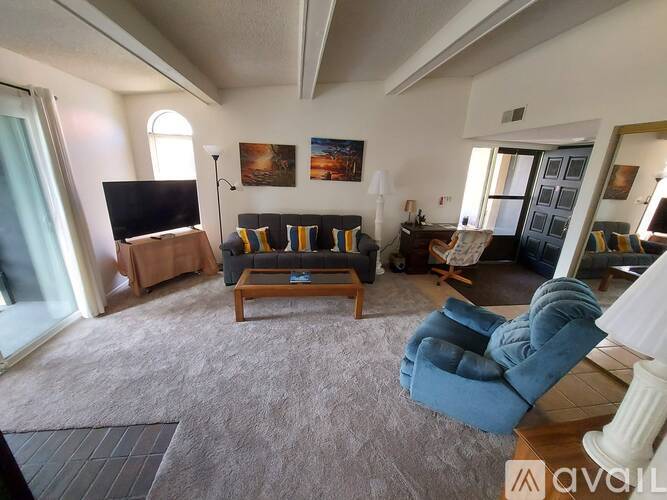A living room with a couch, chair, and television.