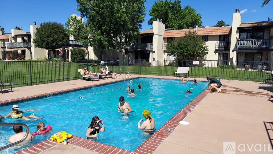A group of people are enjoying a sunny day at the pool.