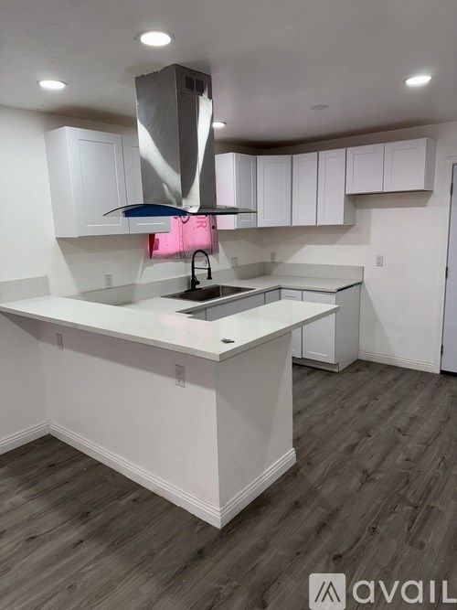 A modern kitchen with white cabinets and a large island.