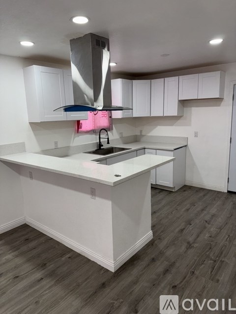 A modern kitchen with white cabinets and a large island.