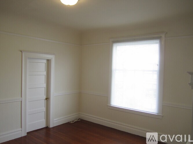 A room with a door and a window with blinds.