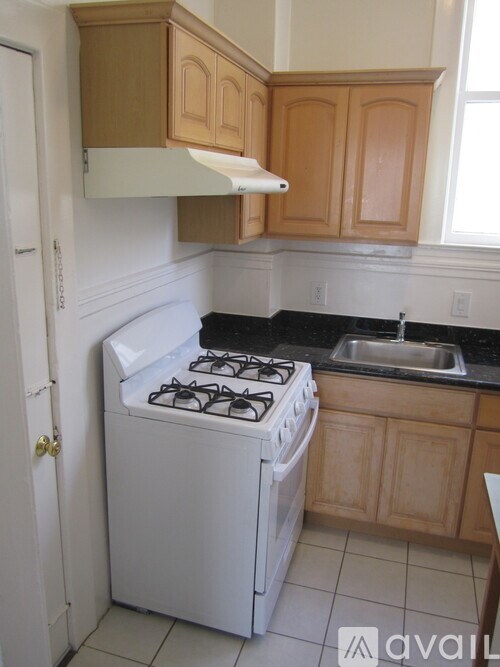 A kitchen with a white stove and wooden cabinets.