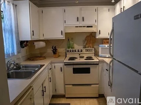 A kitchen with white cabinets and appliances.
