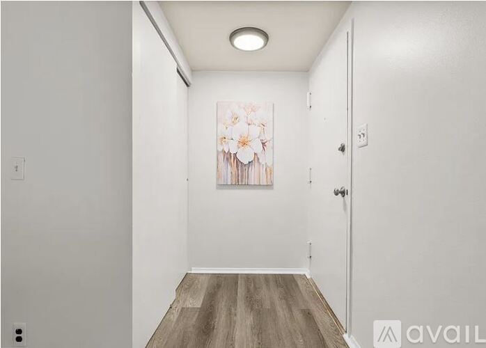 A room with a painting on the wall and a wooden floor.