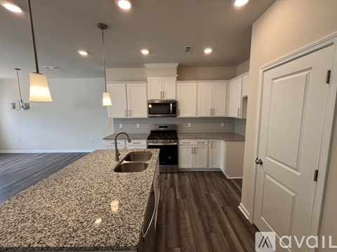 A kitchen with a granite countertop and white cabinets.
