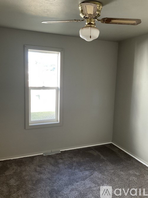 A room with a ceiling fan and a window.