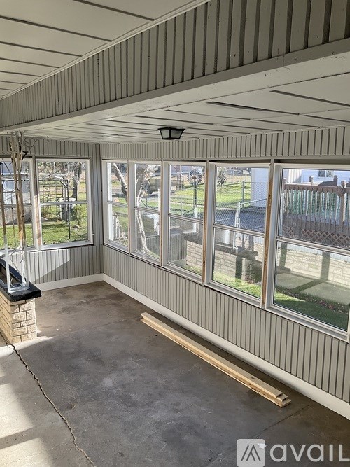 A sunny day in a room with a striped ceiling and a television on a stand.