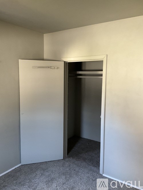 A white door is open in a room with grey carpet.