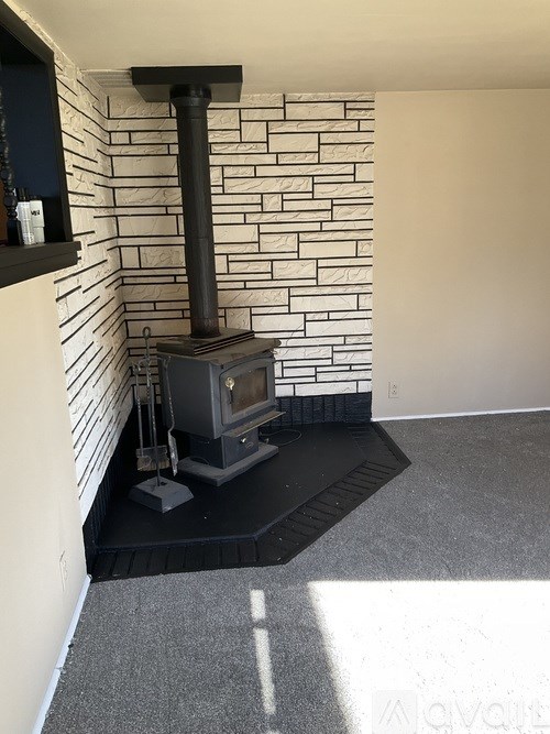 A wood stove is installed in a room with a brick wall.