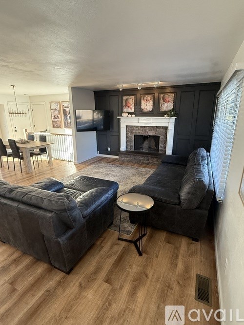 A living room with a fireplace and two couches.