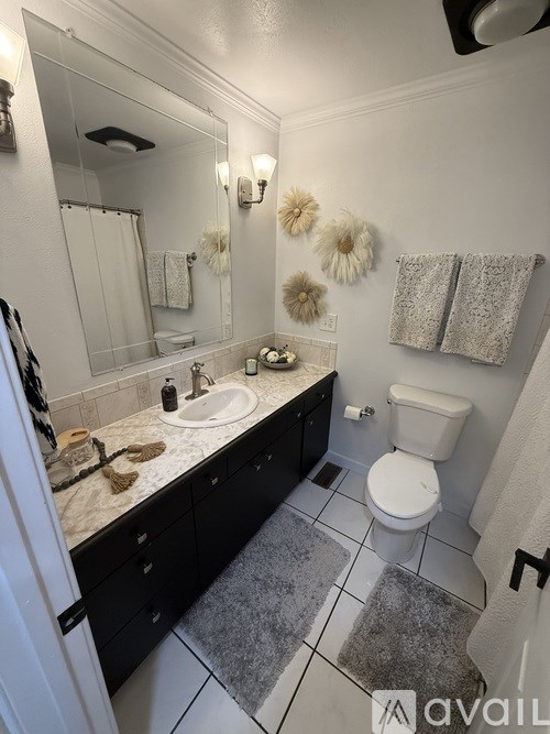 A bathroom with a toilet, sink, and mirror.