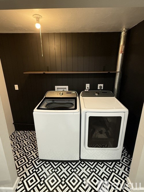 A black and white tiled floor with a white washer and dryer on it.