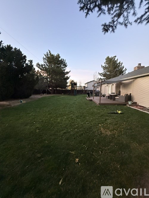 A backyard with a lawn and a house in the background.