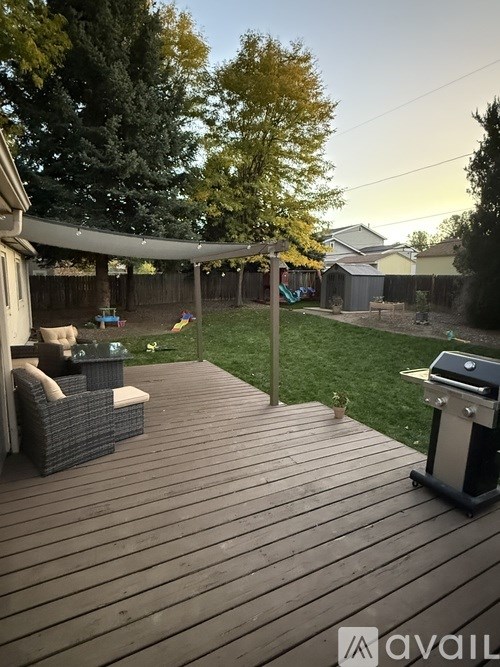 A backyard with a wooden deck and patio furniture.