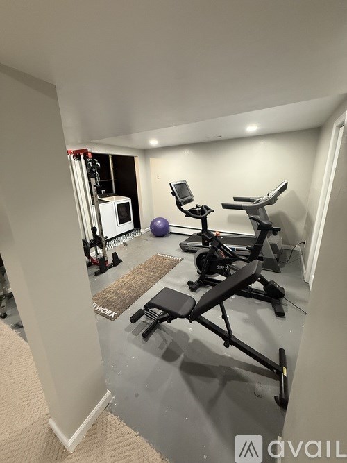 A home gym with a treadmill, exercise bike, and weights.