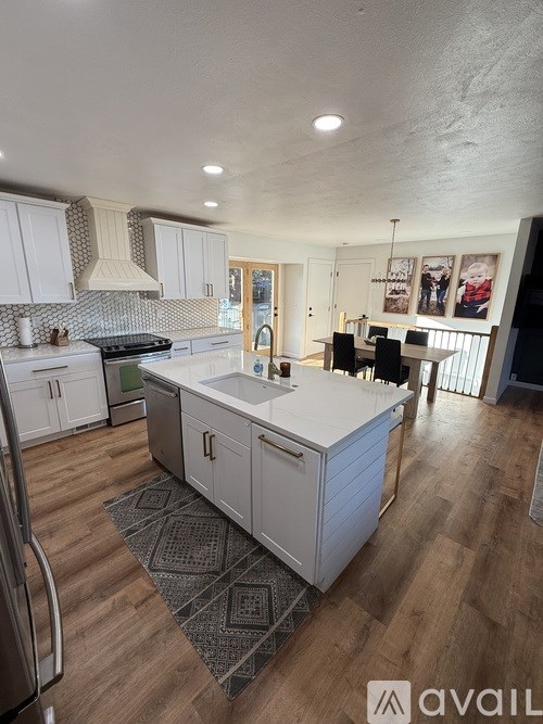 A kitchen with white cabinets and a wooden floor.