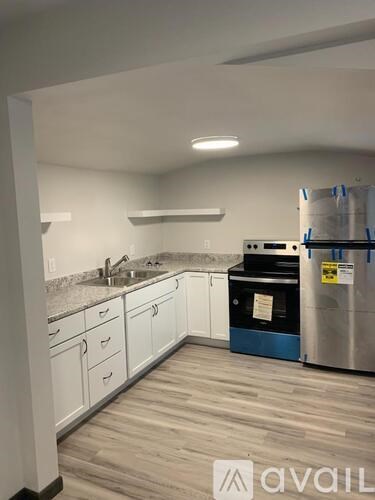 A kitchen with white cabinets and a wooden floor.