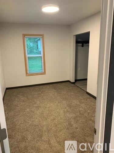 A room with a carpeted floor and a window.