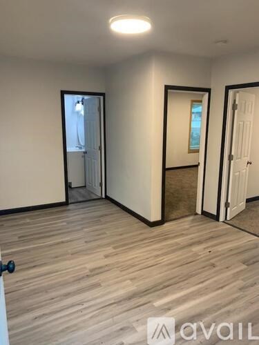 A room with wooden flooring and a mirror on the wall.