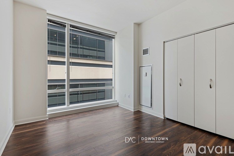 A room with a large window and a wooden floor.