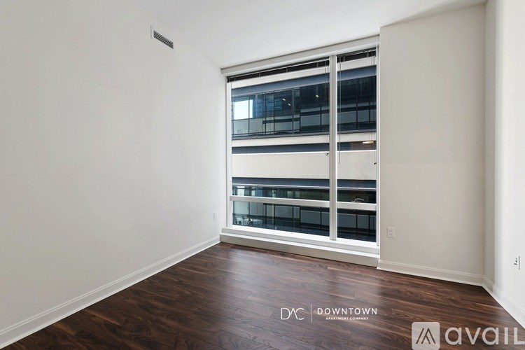 A room with a window overlooking a balcony with a view of a building.