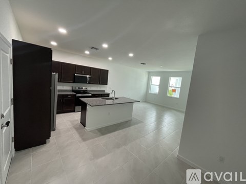 A modern kitchen with dark brown cabinets and a central island.