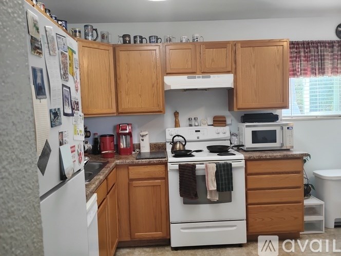 A kitchen with wooden cabinets and white appliances.