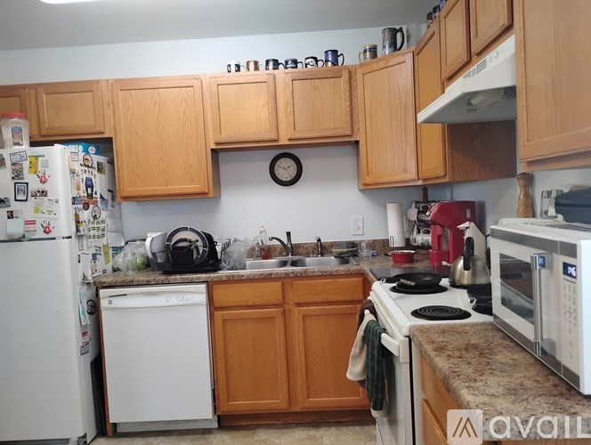 A kitchen with wooden cabinets and a white refrigerator.