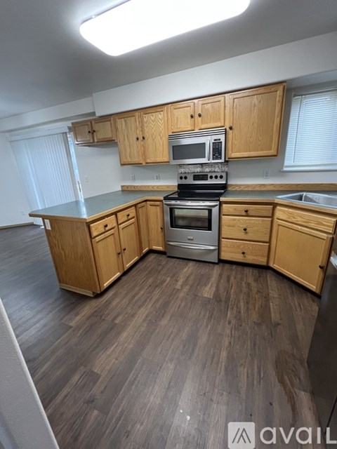 A kitchen with wooden cabinets and a stove top oven.