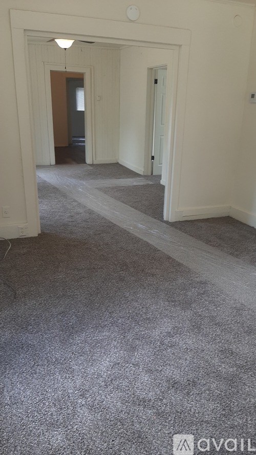 A long hallway with a carpeted floor and white walls.