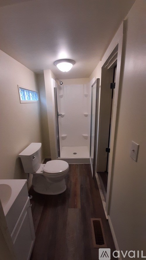 A bathroom with a toilet, sink, and shower.
