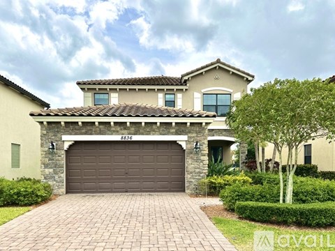 A house with a brown garage door and a stone wall.