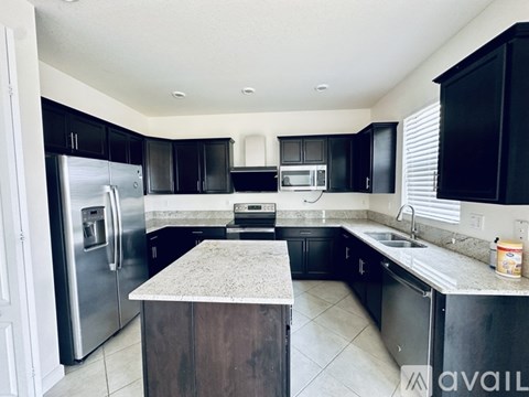 A kitchen with black cabinets and stainless steel appliances.