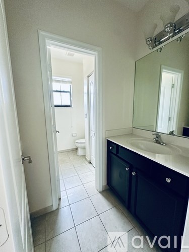 A bathroom with a sink, mirror, and toilet.