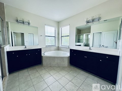 A bathroom with a tub, sink, and mirror.
